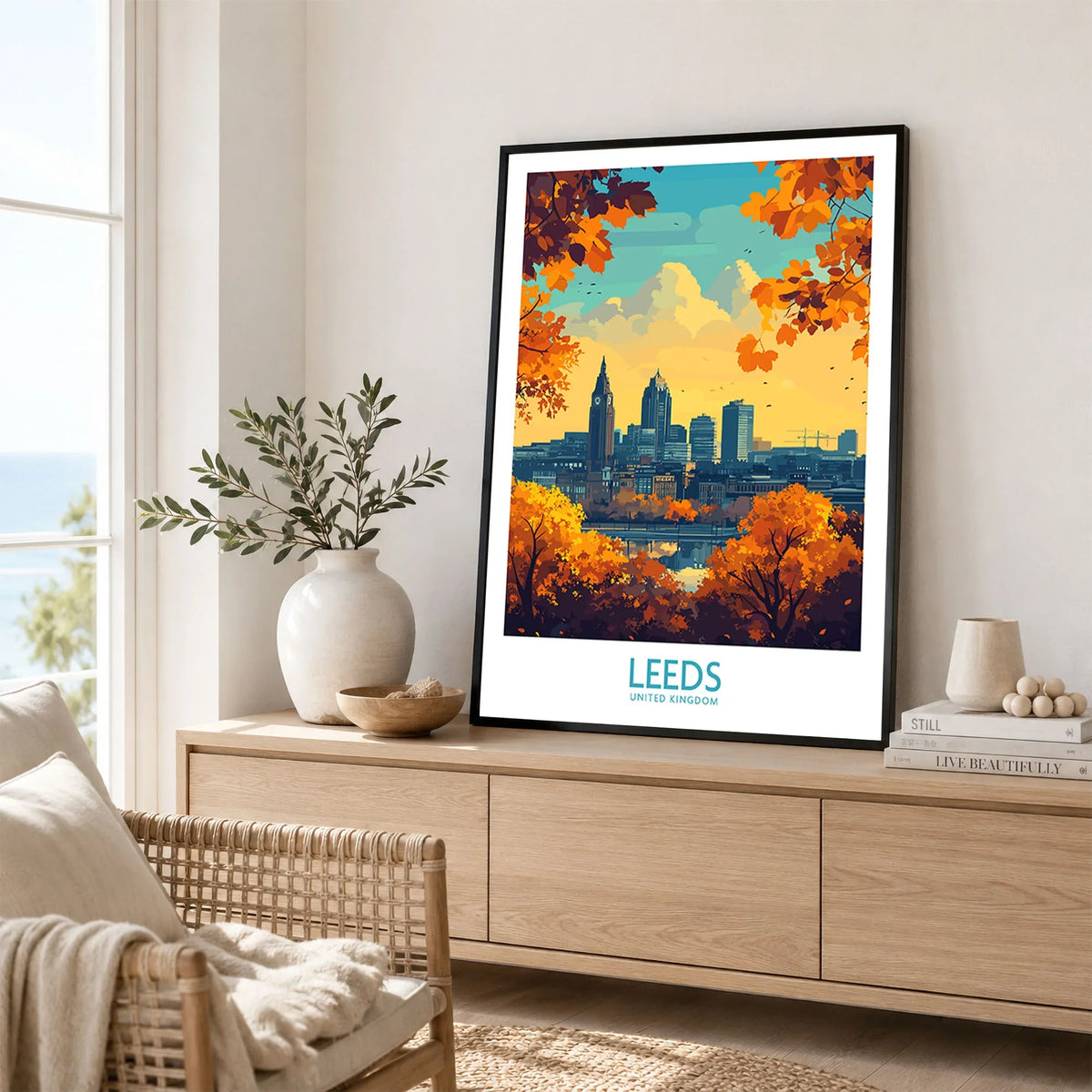 Leeds Travel Poster - United Kingdom in a black frame displayed on an oak sideboard in a bright coastal living room