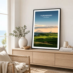 Turnberry Scotland Ailsa Craig Travel Poster — Ailsa Craig and the white lighthouse across rolling coastal turf at dusk, shown as framed artwork living room lifestyle setting