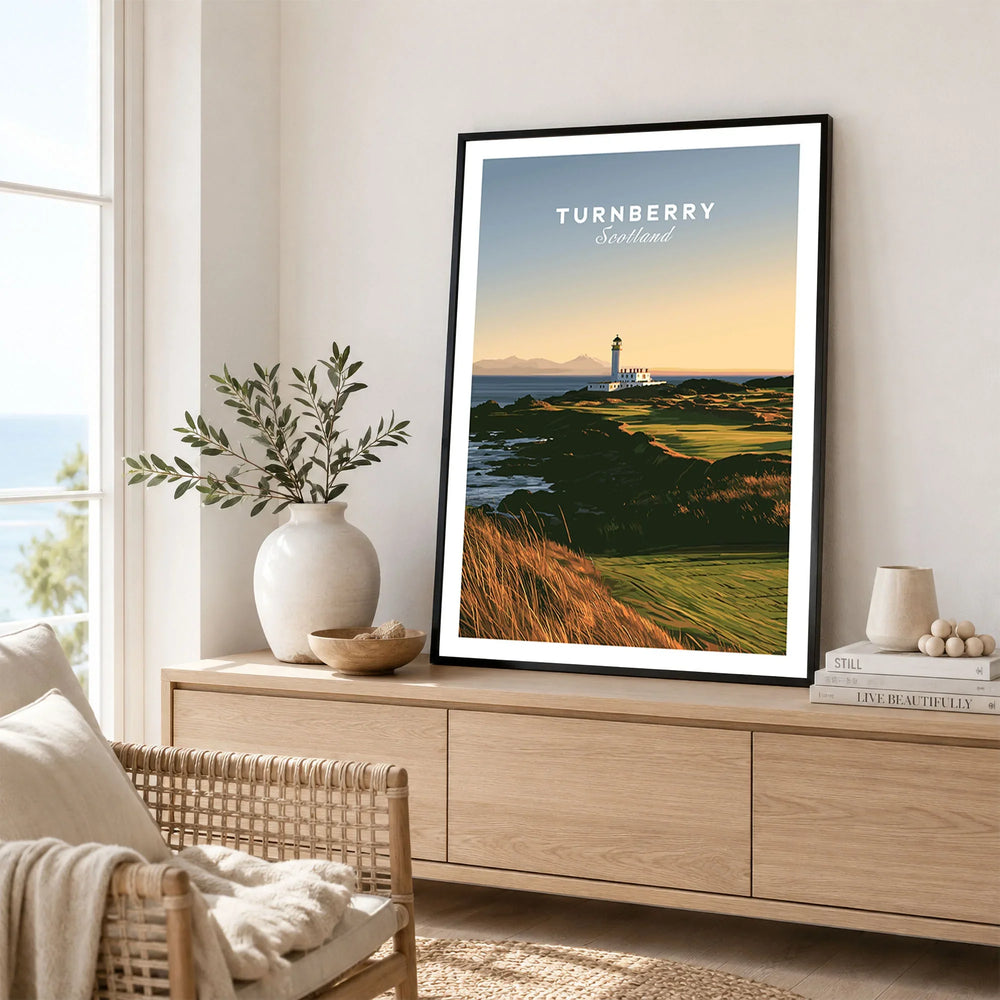 Turnberry Scotland Lighthouse Travel Poster — the Turnberry lighthouse above a rocky shore with the Arran hills beyond, shown as framed artwork living room lifestyle setting