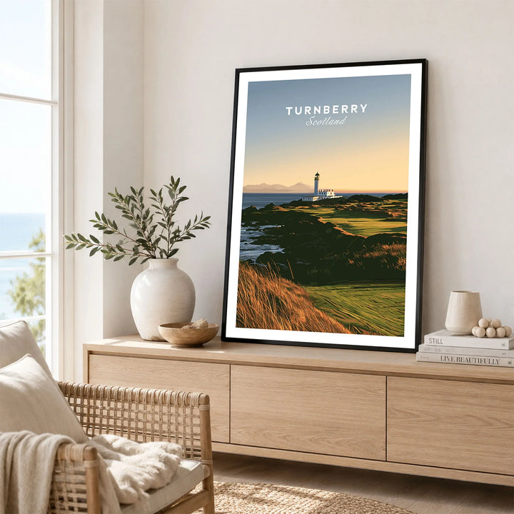 Turnberry Scotland Lighthouse Travel Poster — the Turnberry lighthouse above a rocky shore with the Arran hills beyond, shown as framed artwork living room lifestyle setting
