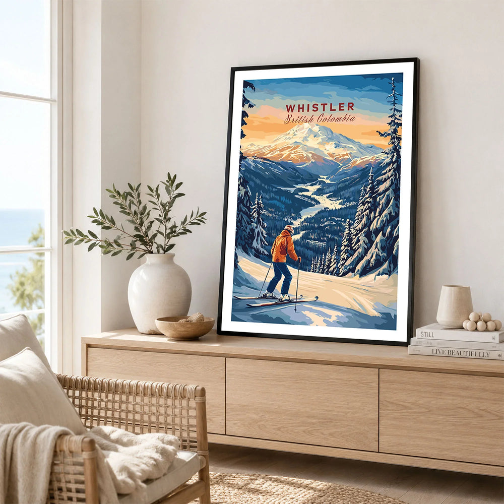 Whistler Travel Poster -  British Columbia in a black frame displayed on an oak sideboard in a bright coastal living room