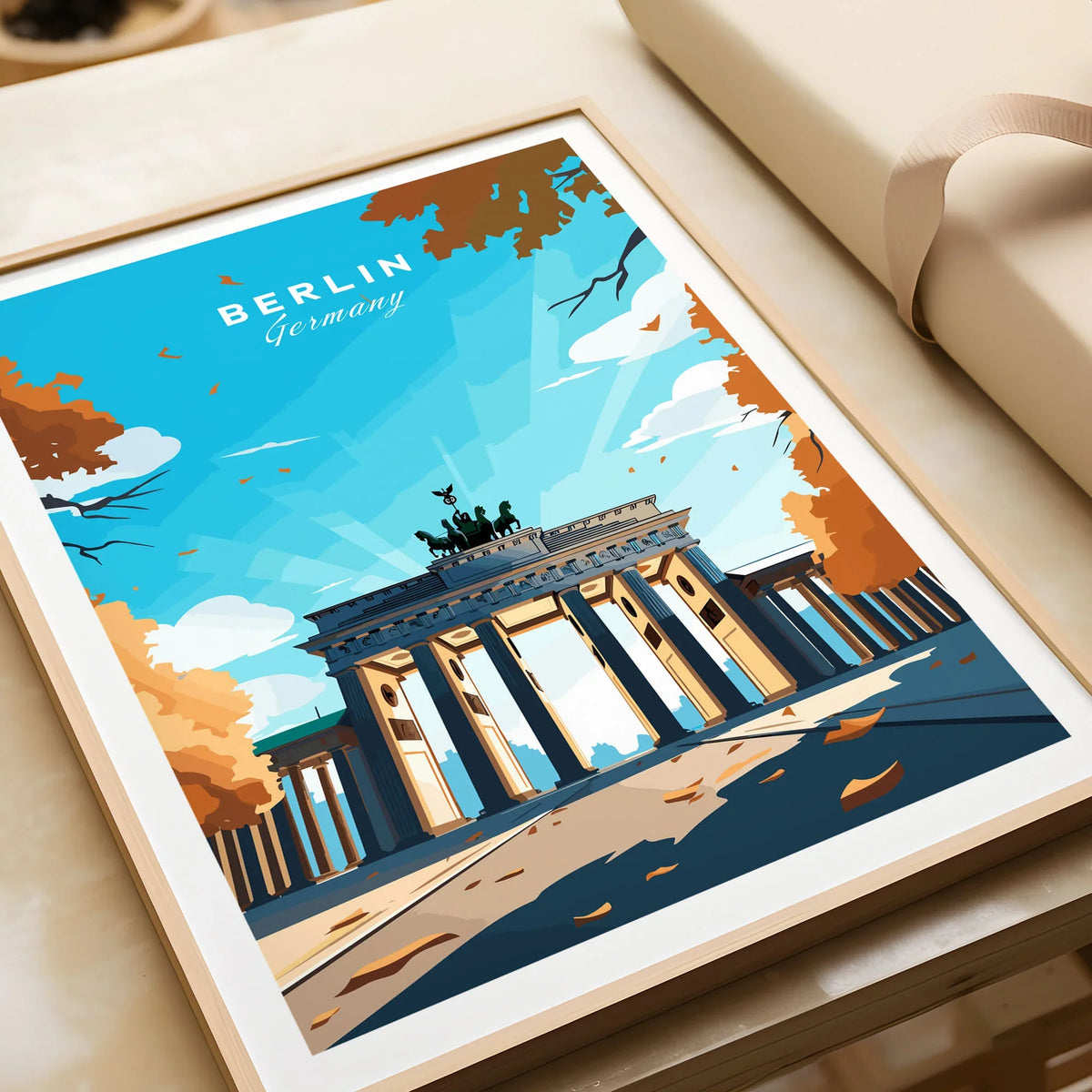 Berlin Poster Blue Sky in a natural wood frame beside wrapped gift packaging, close-up detail