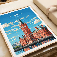 Cardiff Travel Poster in a natural wood frame beside wrapped gift packaging, close-up detail