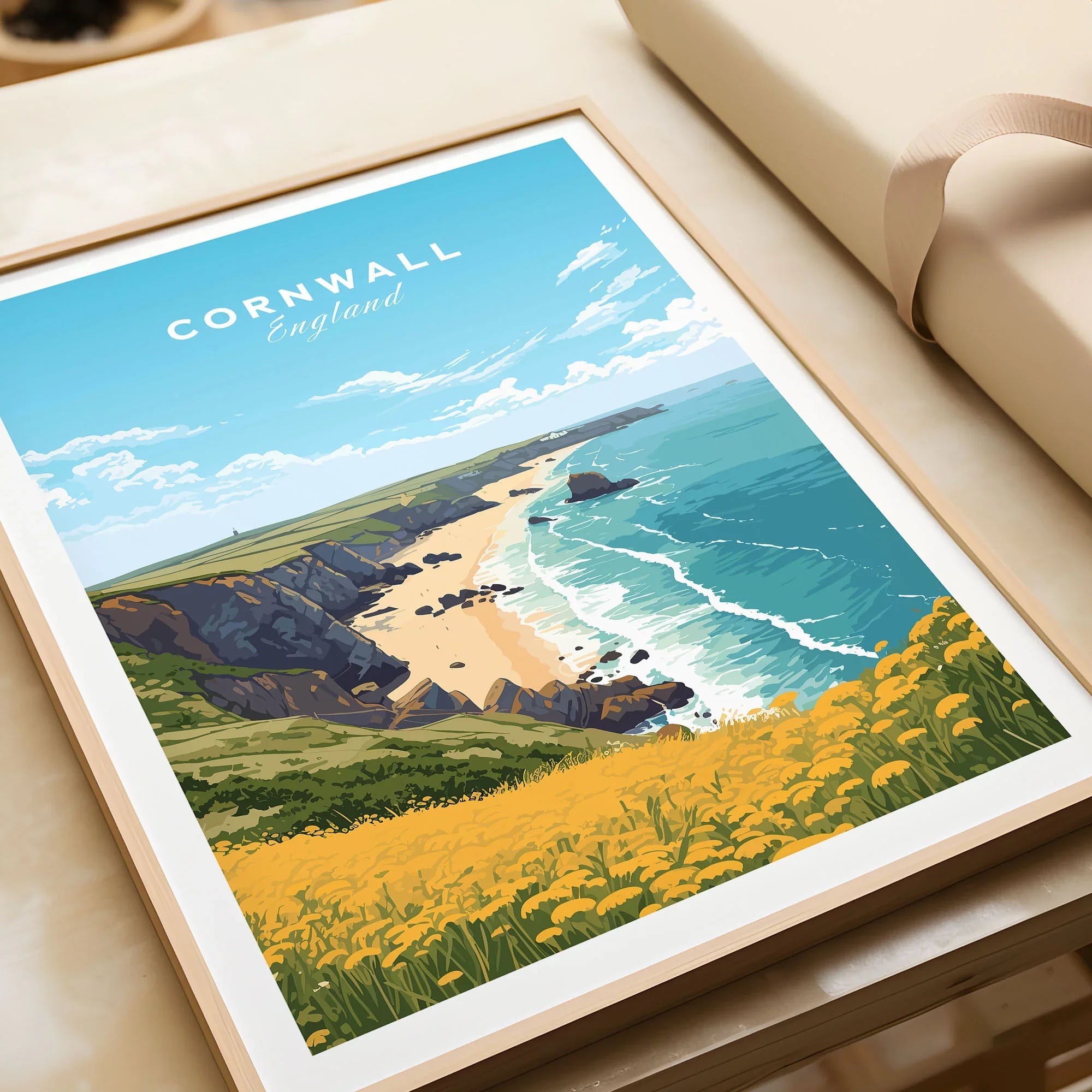 Cornwall Poster in a natural wood frame beside wrapped gift packaging, close-up detail