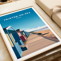Frinton-on-Sea Travel Poster – Essex Coastline Beach Huts & Prom Art in a natural wood frame beside wrapped gift packaging, close-up detail
