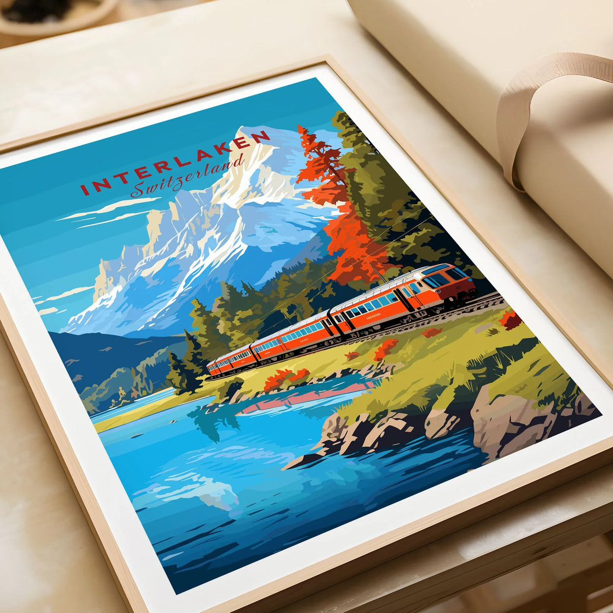 Interlaken Print Switzerland in a natural wood frame beside wrapped gift packaging, close-up detail