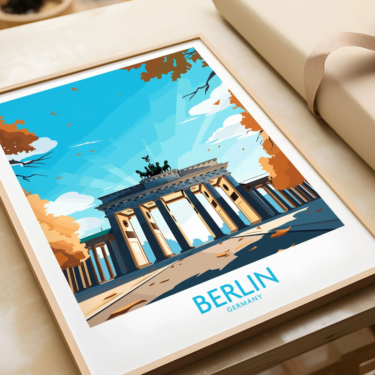 Berlin Wall Art Modern in a natural wood frame beside wrapped gift packaging, close-up detail