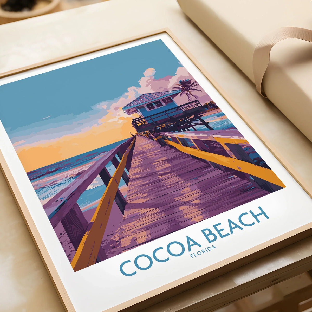 Cocoa Beach Florida Wooden Pier Poster - Golden Hour Sunset Decor in a natural wood frame beside wrapped gift packaging, close-up detail