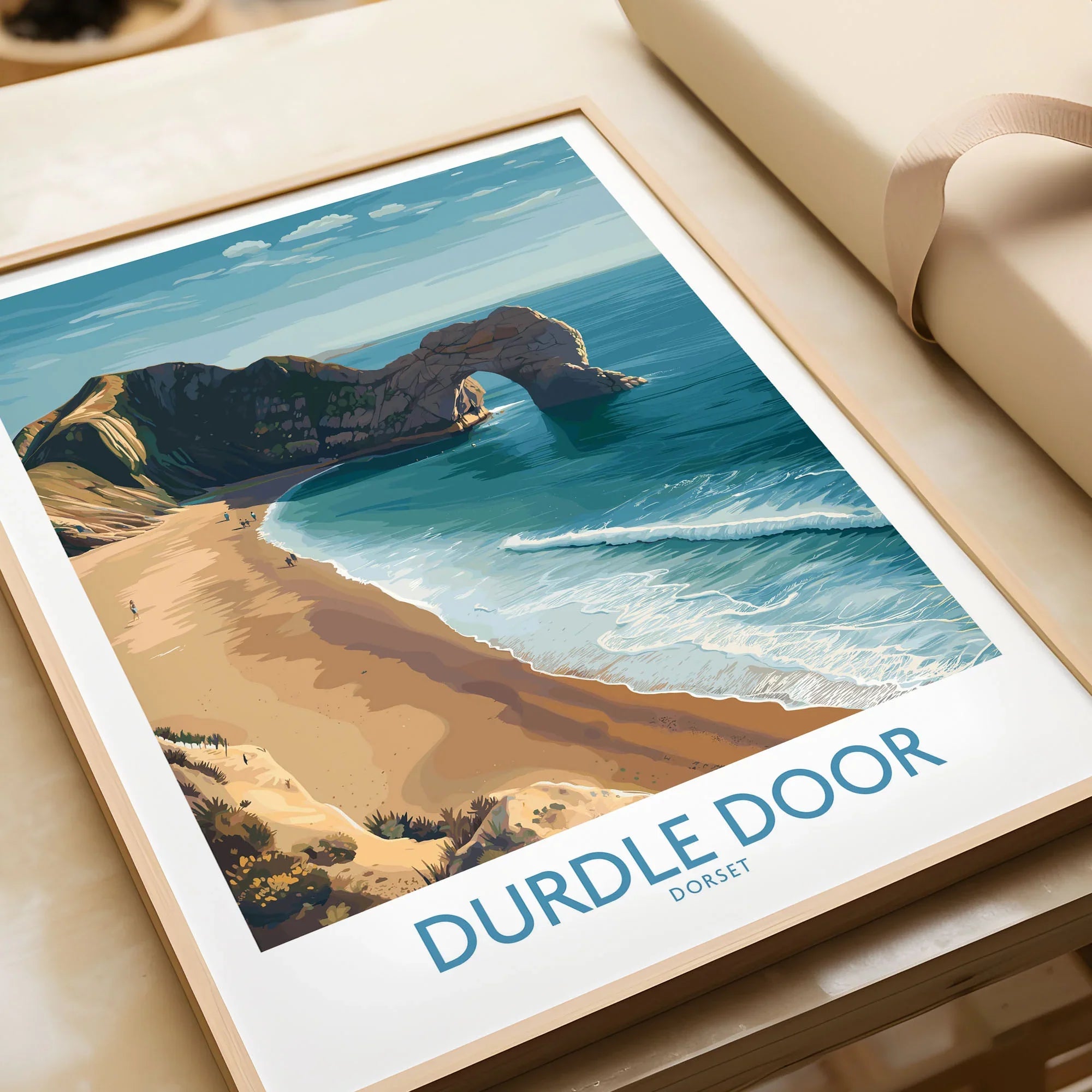Durdle Door Art Print Dorset Wall Art in a natural wood frame beside wrapped gift packaging, close-up detail
