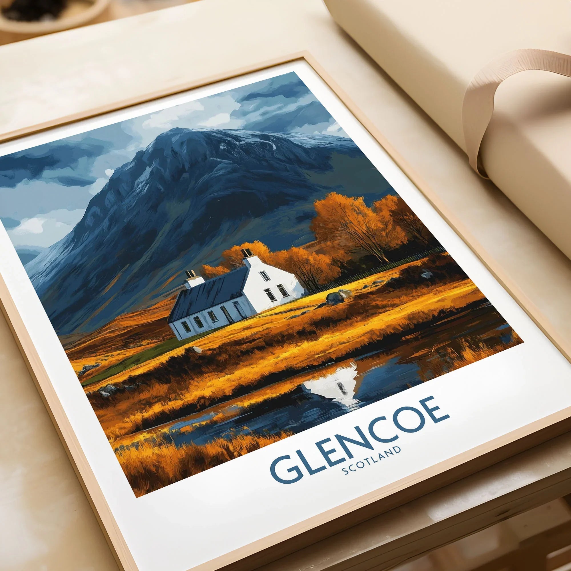 Glencoe Scotland Print in a natural wood frame beside wrapped gift packaging, close-up detail