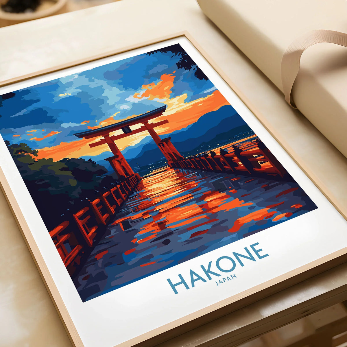 Hakone Wall Art - Japan Travel Poster in a natural wood frame beside wrapped gift packaging, close-up detail