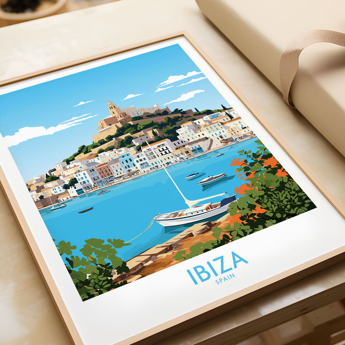 Ibiza Poster in a natural wood frame beside wrapped gift packaging, close-up detail