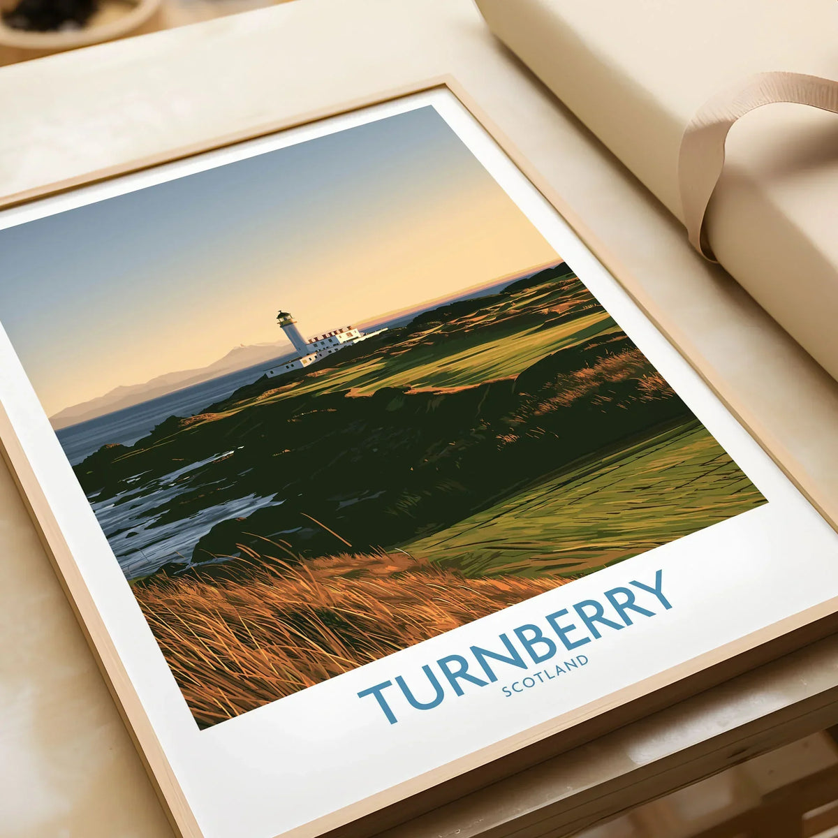 Turnberry Scotland Rocky Shore Wall Art — the Turnberry lighthouse above a rocky shore with the Arran hills beyond, shown as framed art print closeup gift unwrapped natural frame