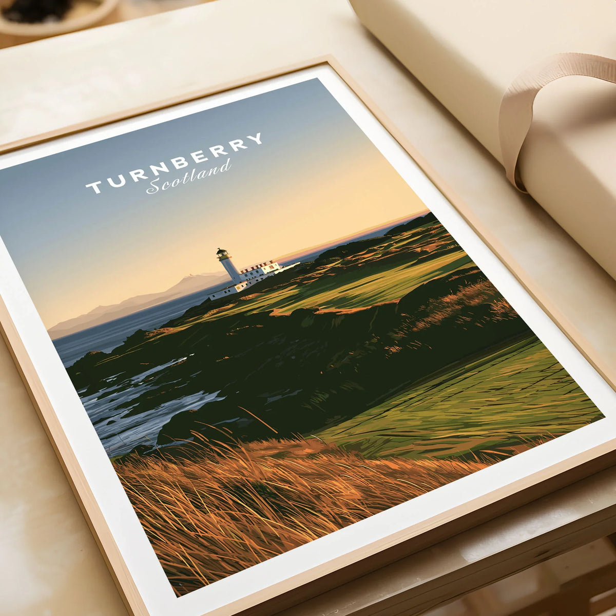 Turnberry Scotland Lighthouse Travel Poster — the Turnberry lighthouse above a rocky shore with the Arran hills beyond, shown as framed art print closeup gift unwrapped natural frame