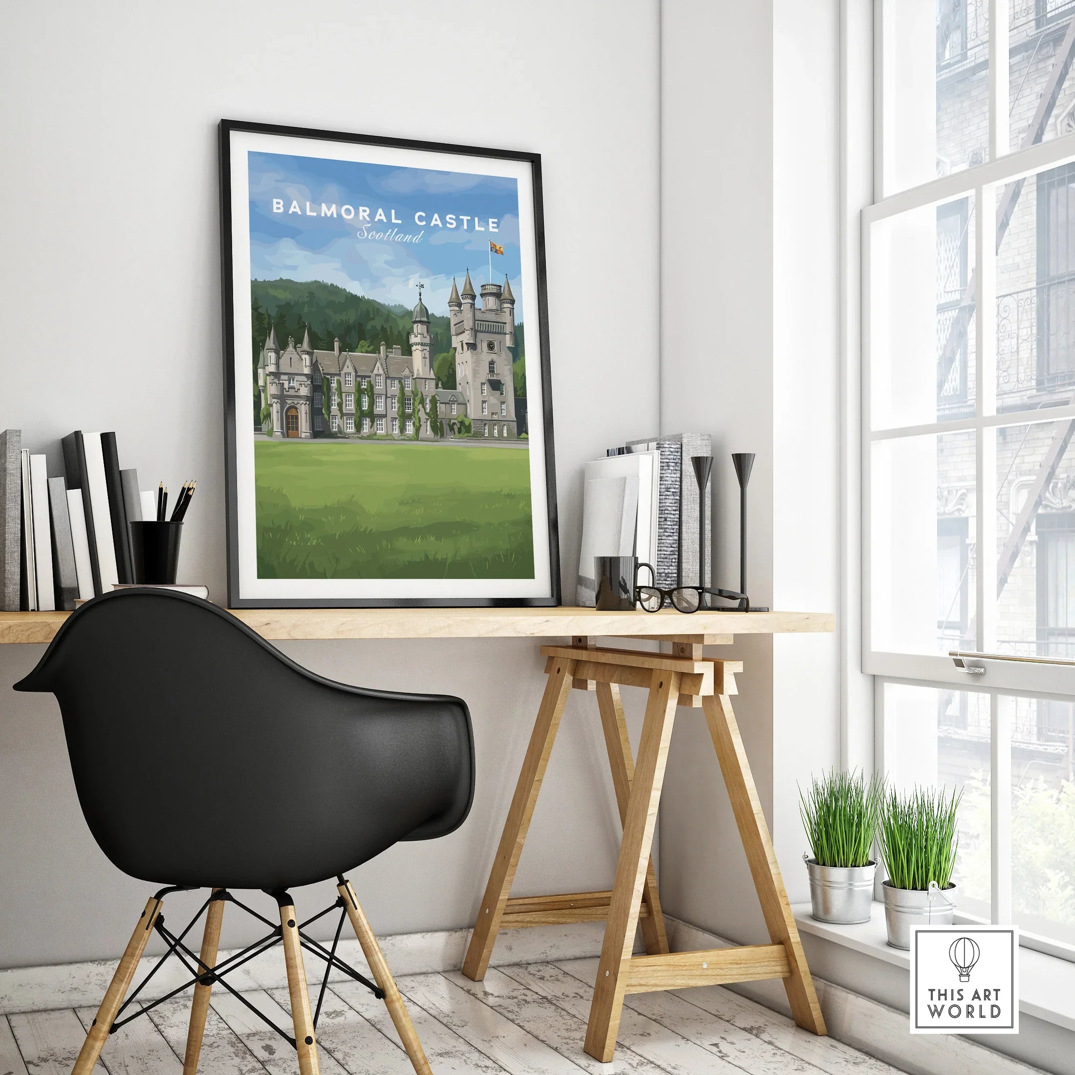 Framed Balmoral Castle travel poster on modern office desk near window, stylish decor