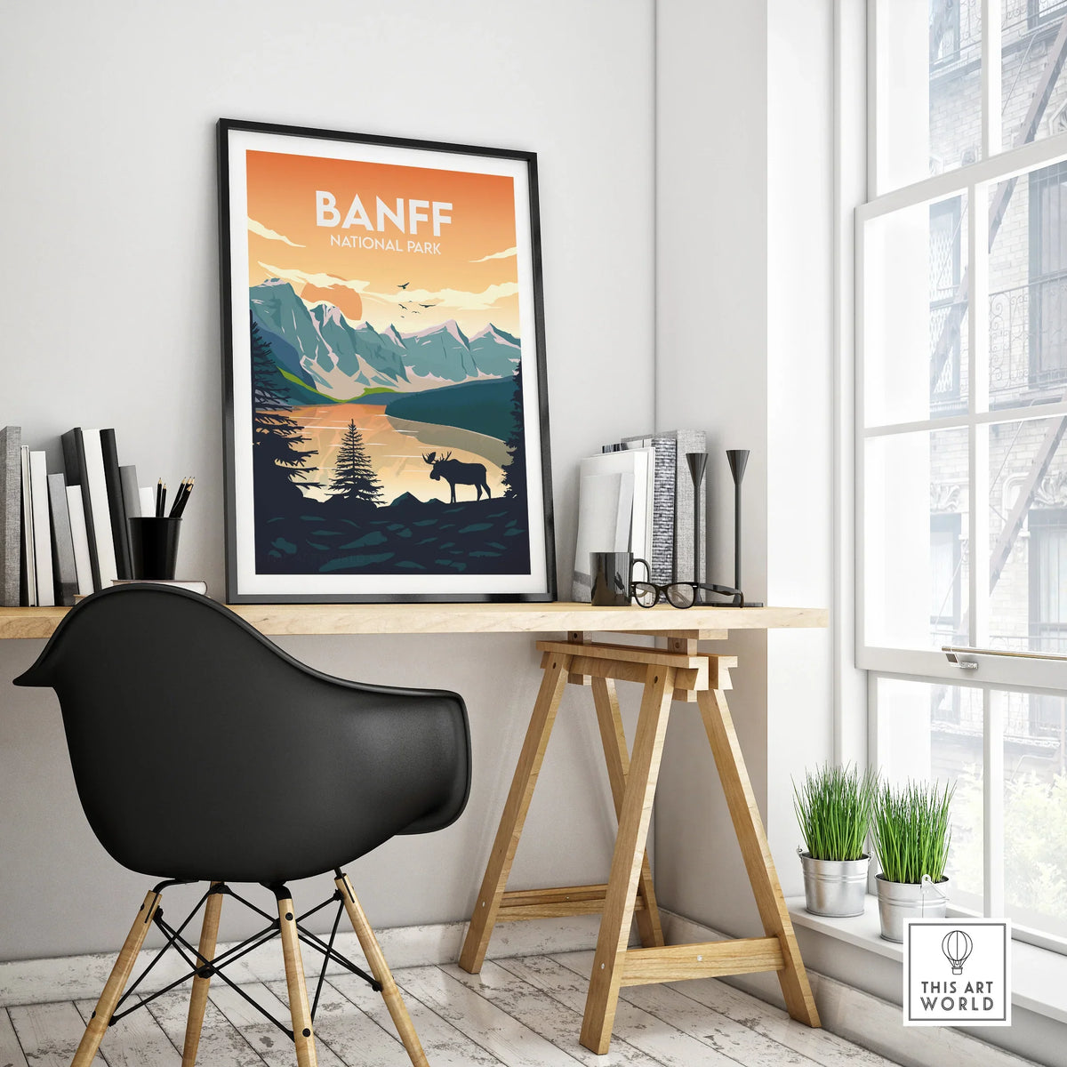 Banff National Park travel poster in black frame on modern office desk, mountain wall art