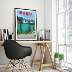 Framed Banff National Park travel poster on a modern office desk with chair and decor