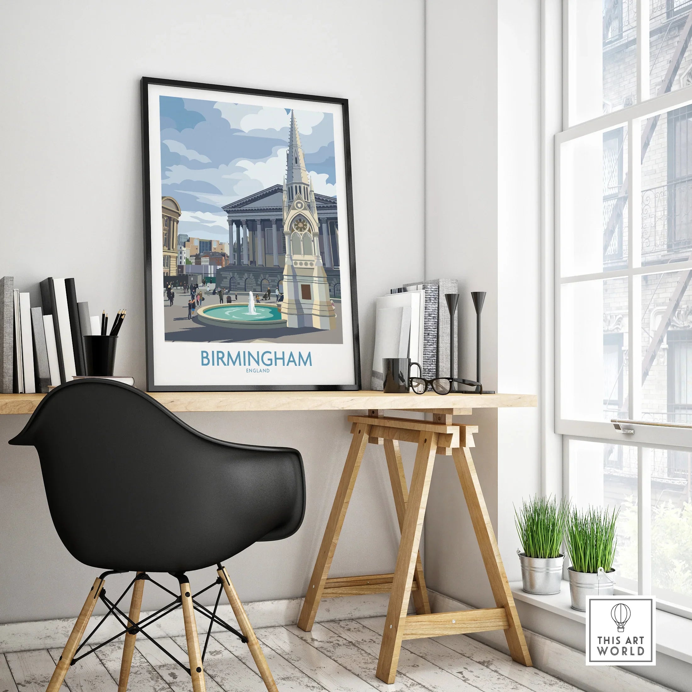 Framed Birmingham travel poster with city landmarks on modern office desk near window