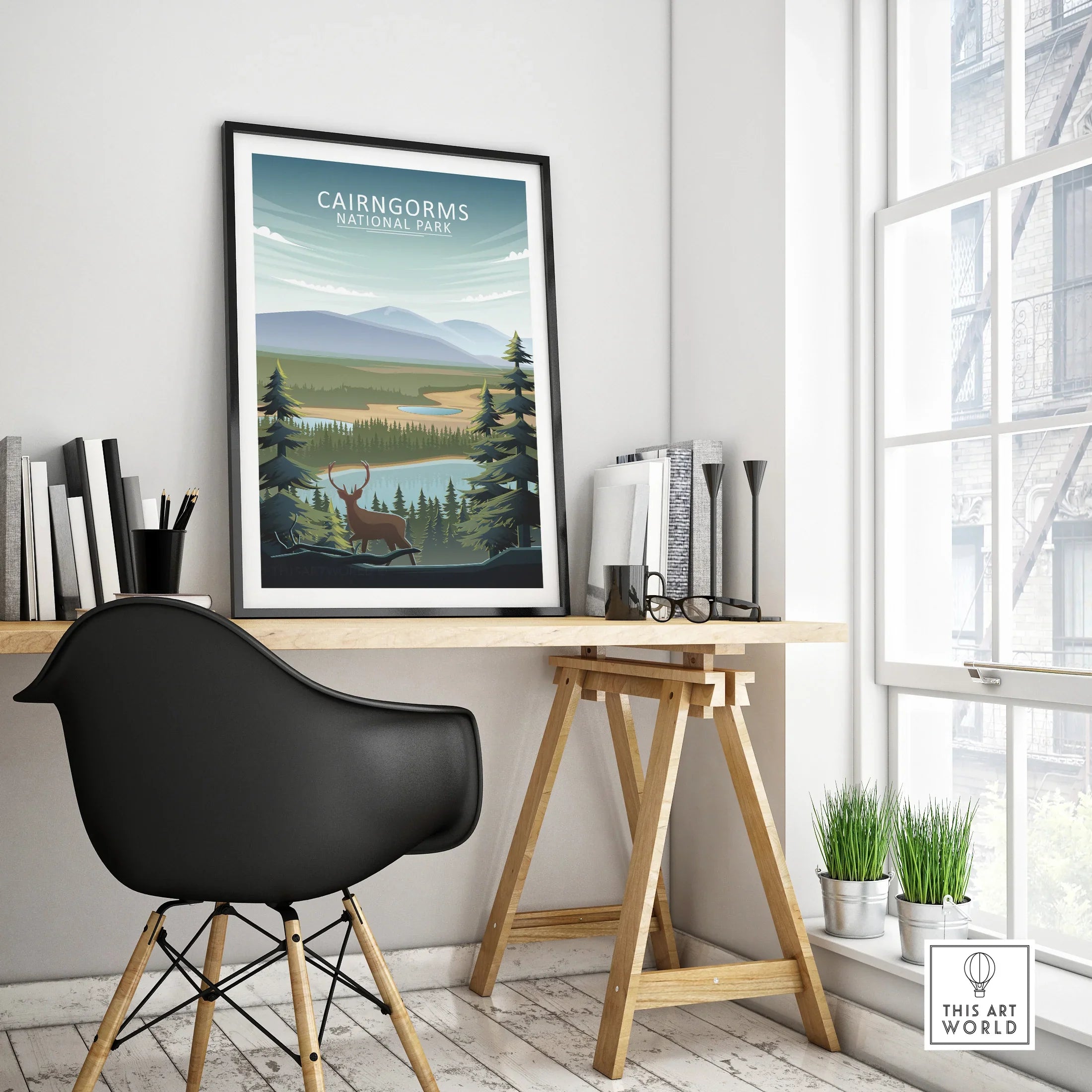 Framed Cairngorms National Park travel poster on modern office desk with black chair