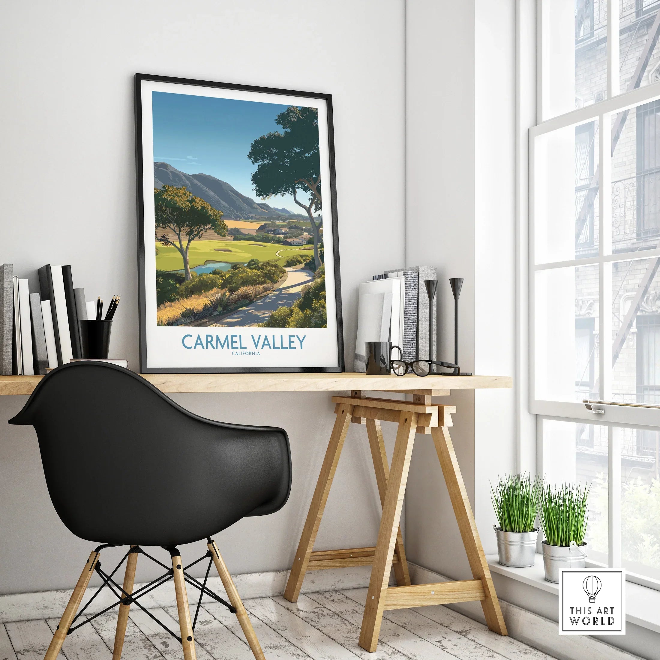 Framed Carmel Valley travel poster on modern office desk with black chair and natural light