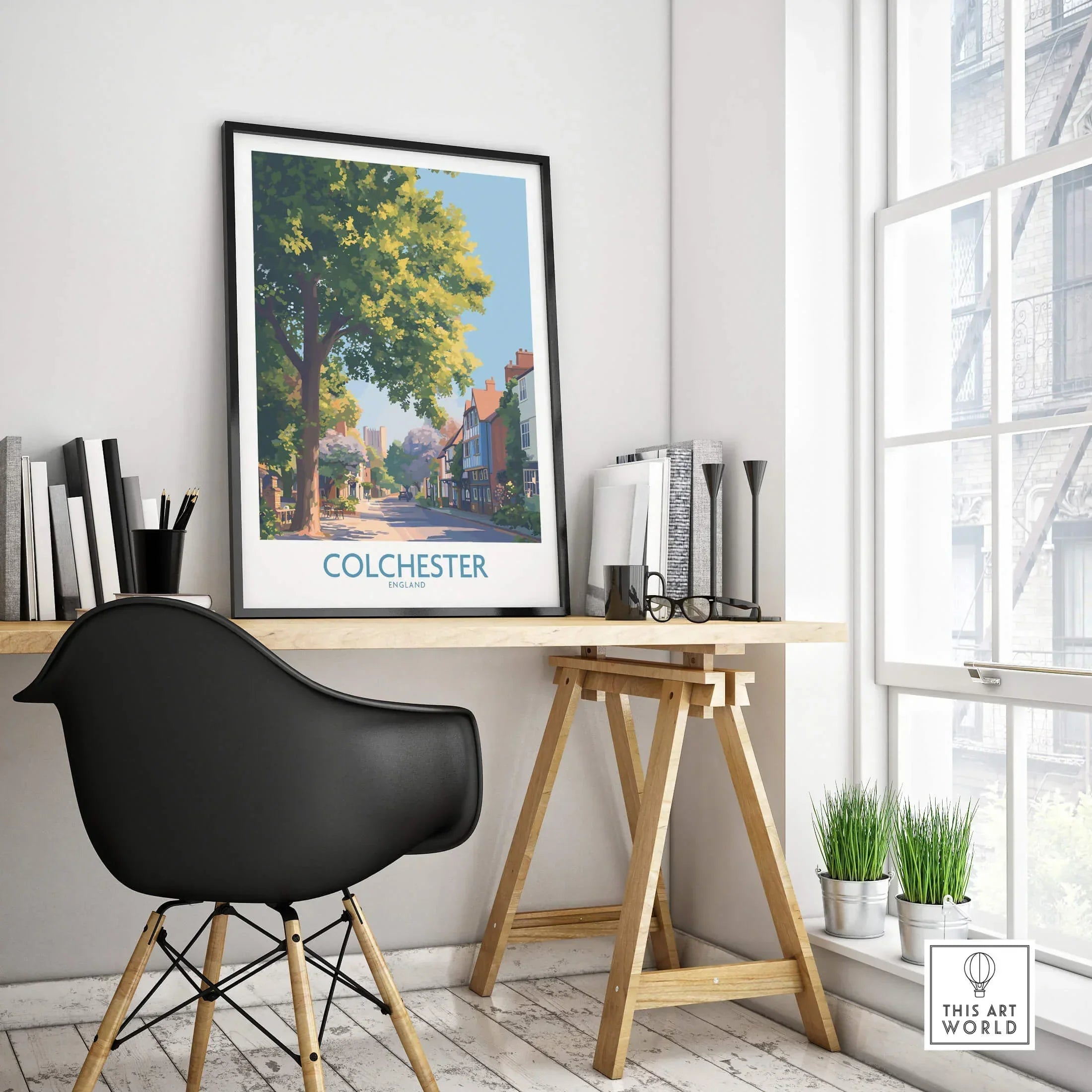 Framed Colchester travel poster on modern office desk with black chair and decor
