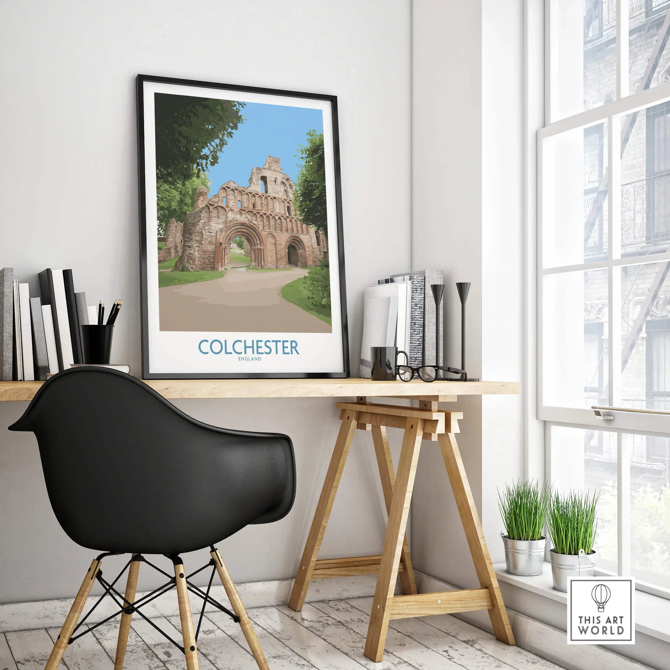 Colchester travel poster with historic ruins in black frame on modern office desk