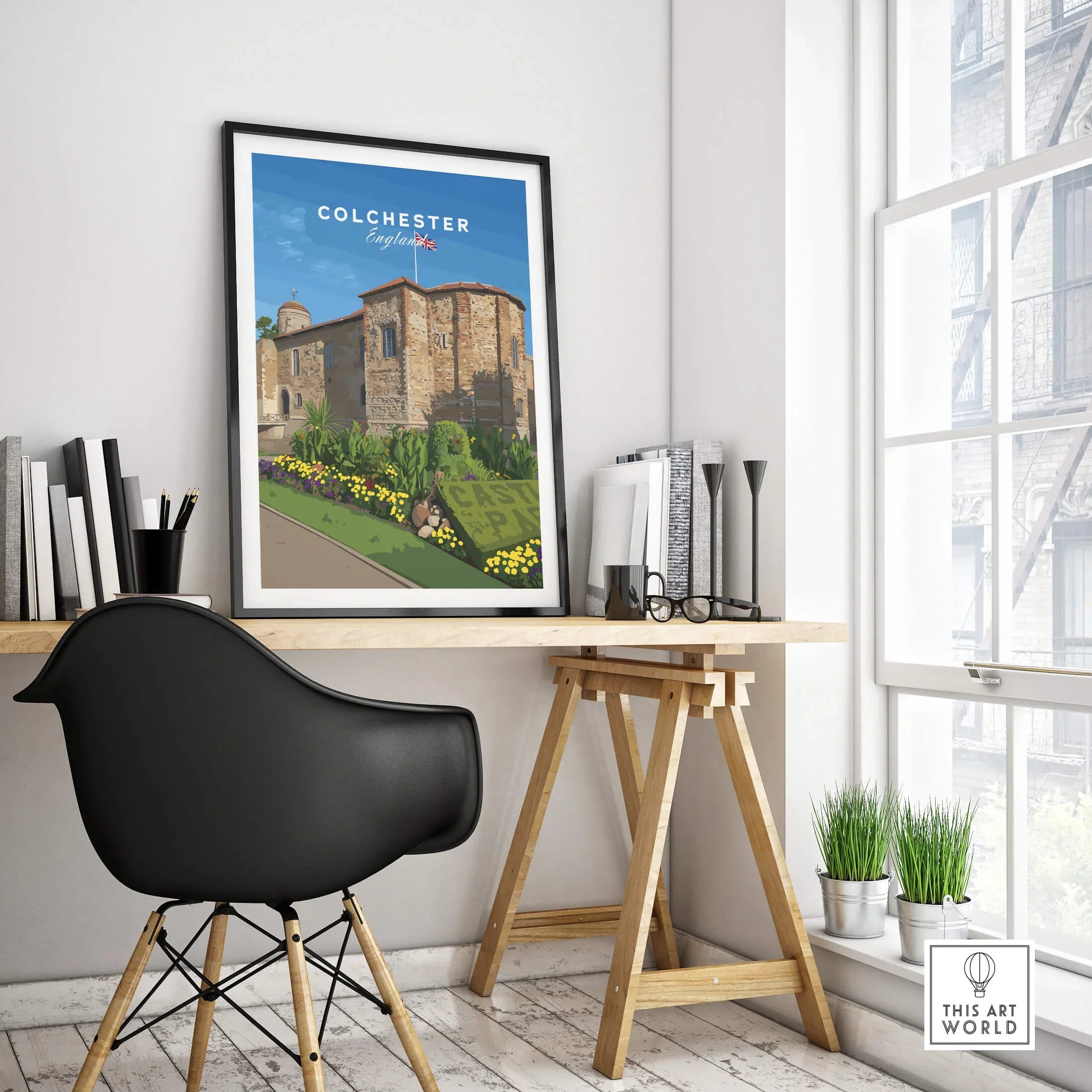 Framed Colchester England travel poster on modern office desk with chair and plants