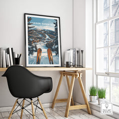 Stylish interior featuring a Copper Mountain Ski Print above a wooden desk and a black chair.
