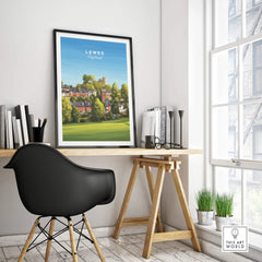 Framed Lewes England travel poster on modern office desk with black chair and books