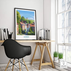 Framed Lewes England travel poster on modern office desk with black chair and books