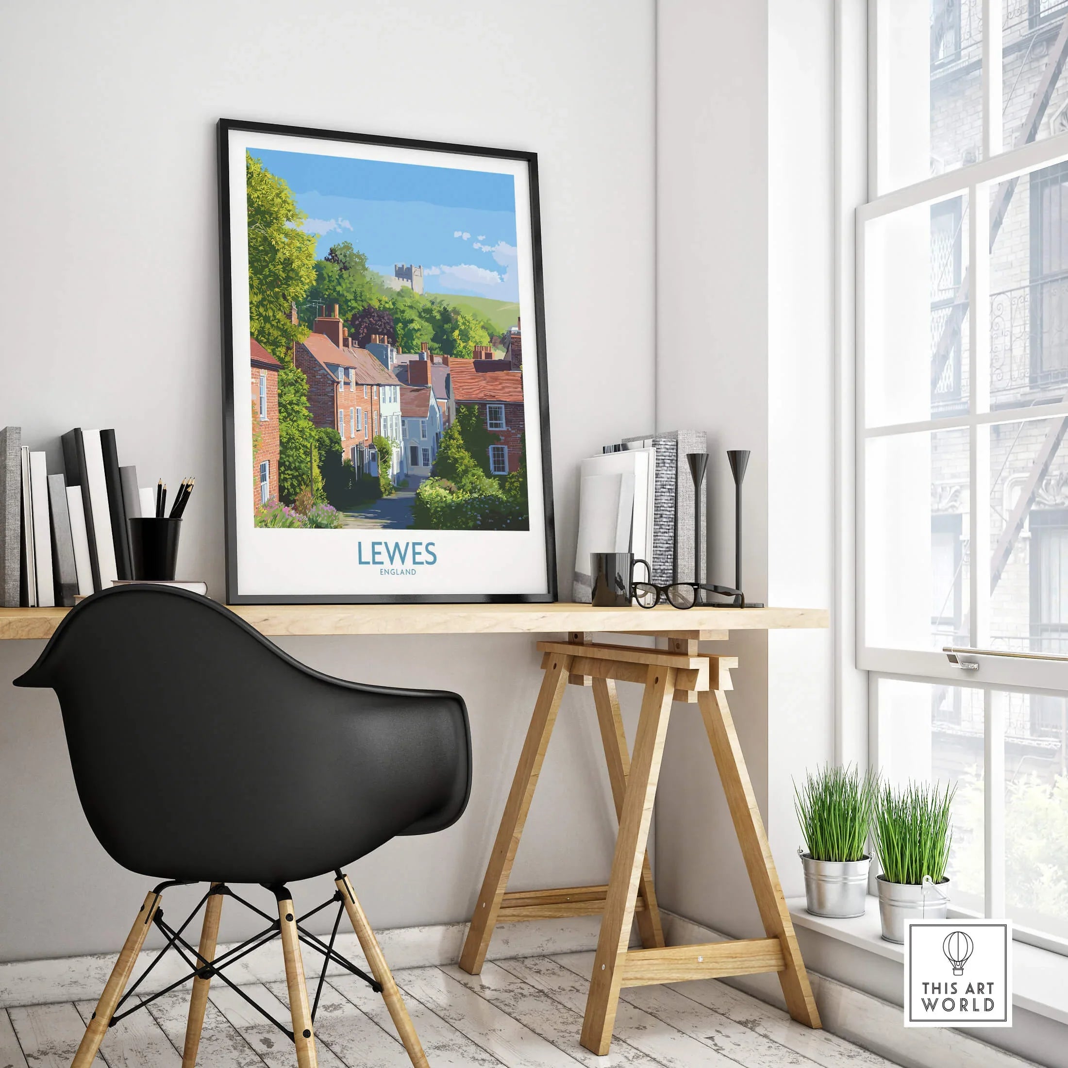 Framed Lewes England travel poster on modern office desk with black chair and books