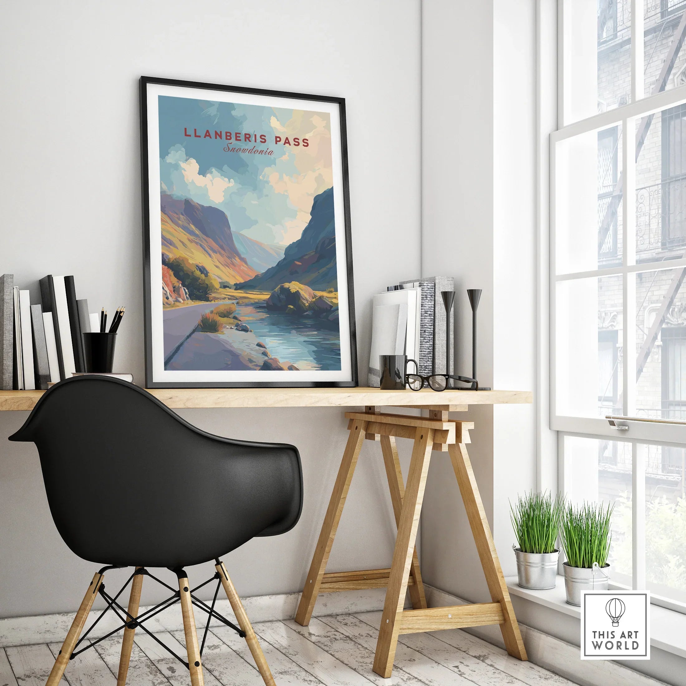 Framed Llanberis Pass travel poster with mountain art on modern office desk by window