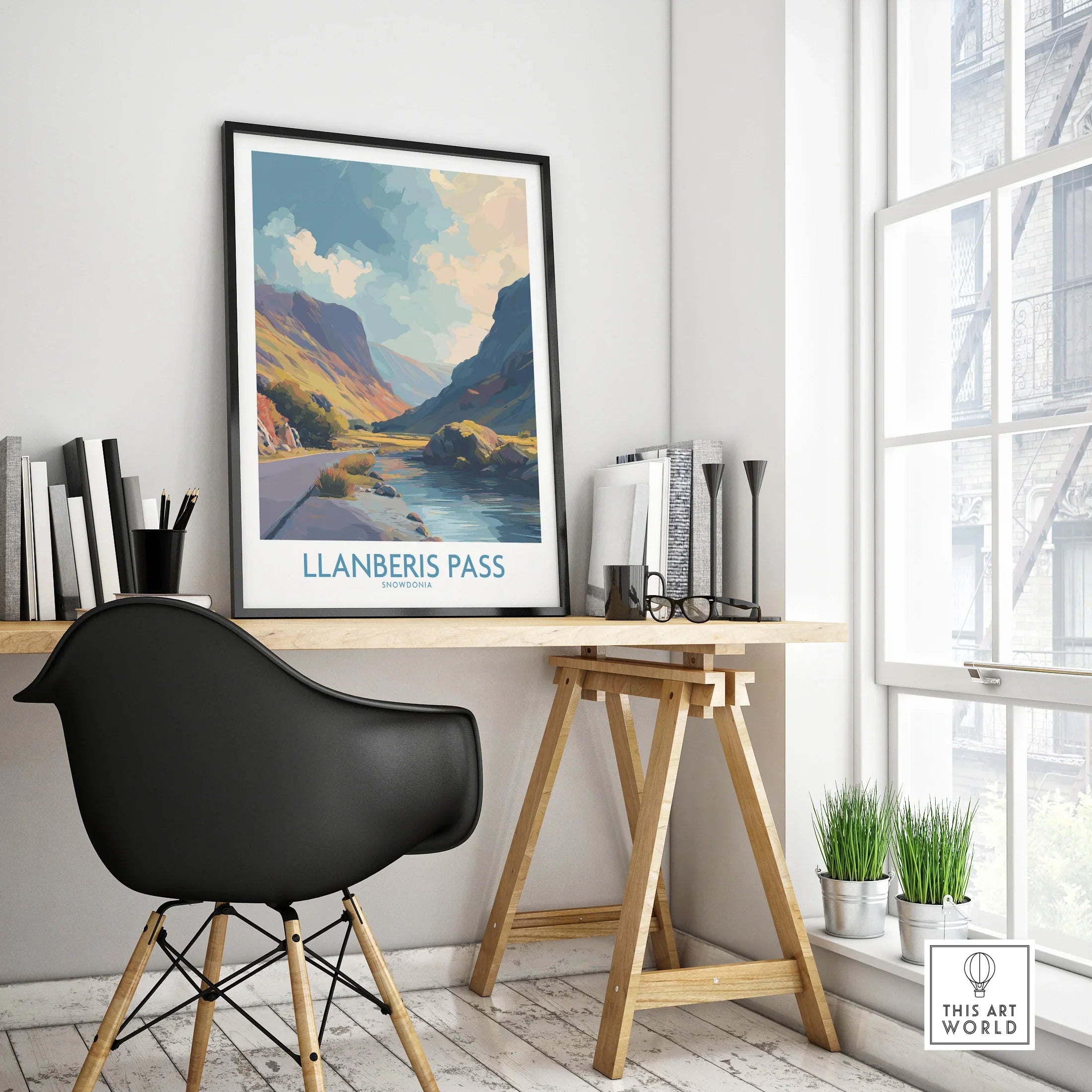 Framed Llanberis Pass Snowdonia travel poster on modern office desk with black chair