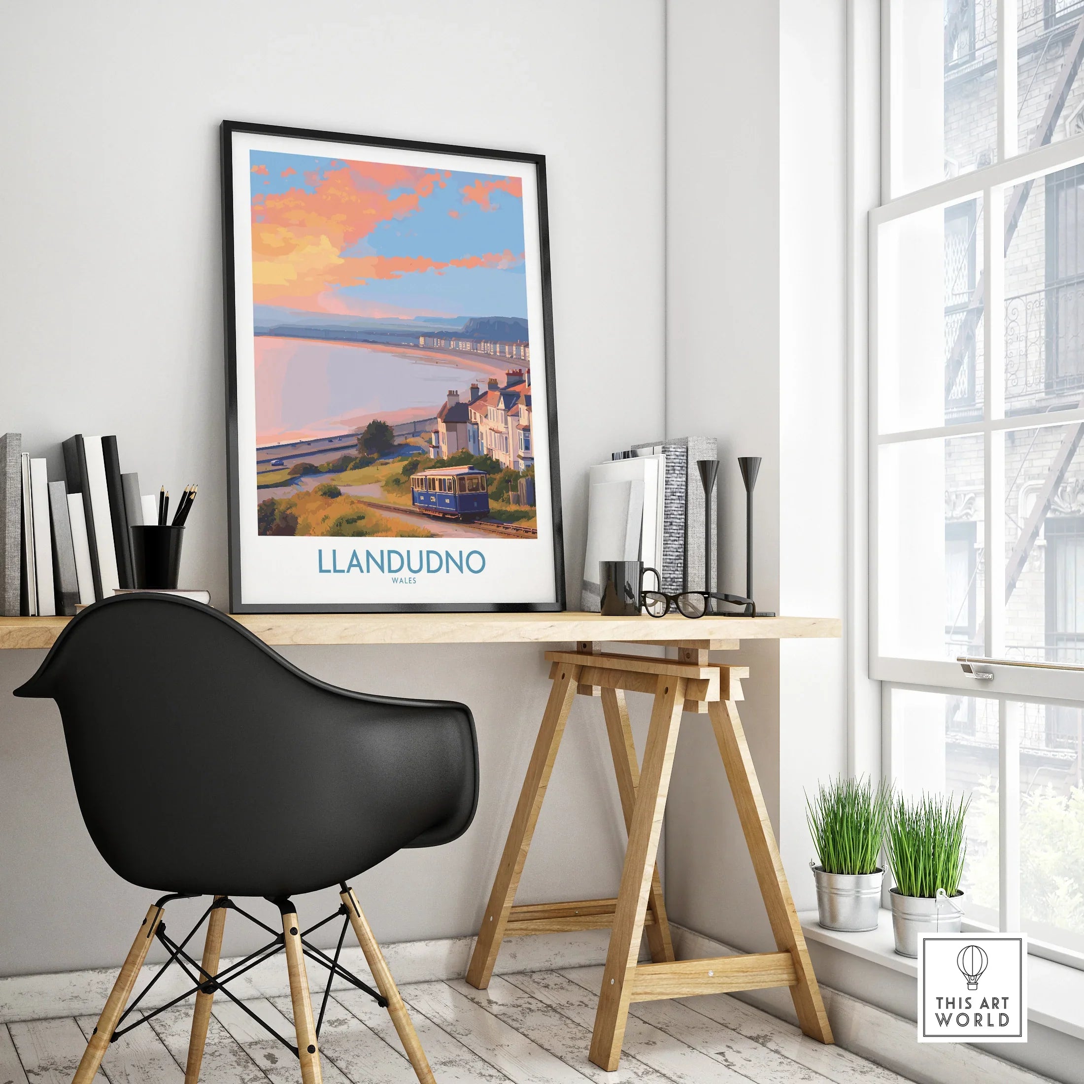 Framed Llandudno travel poster on modern office desk, showcasing scenic seaside art print.