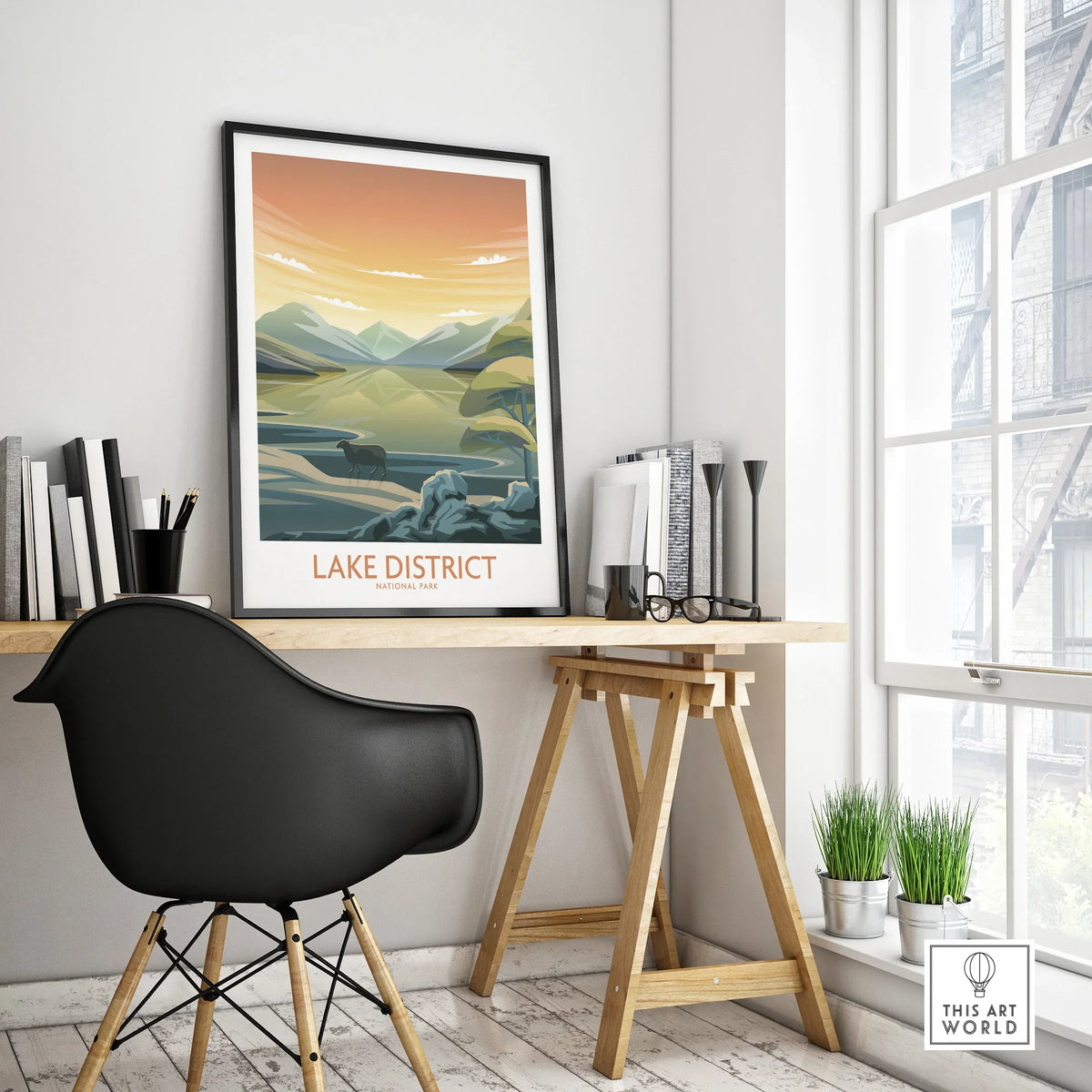 Framed Lake District travel poster on modern office desk with black chair and decor