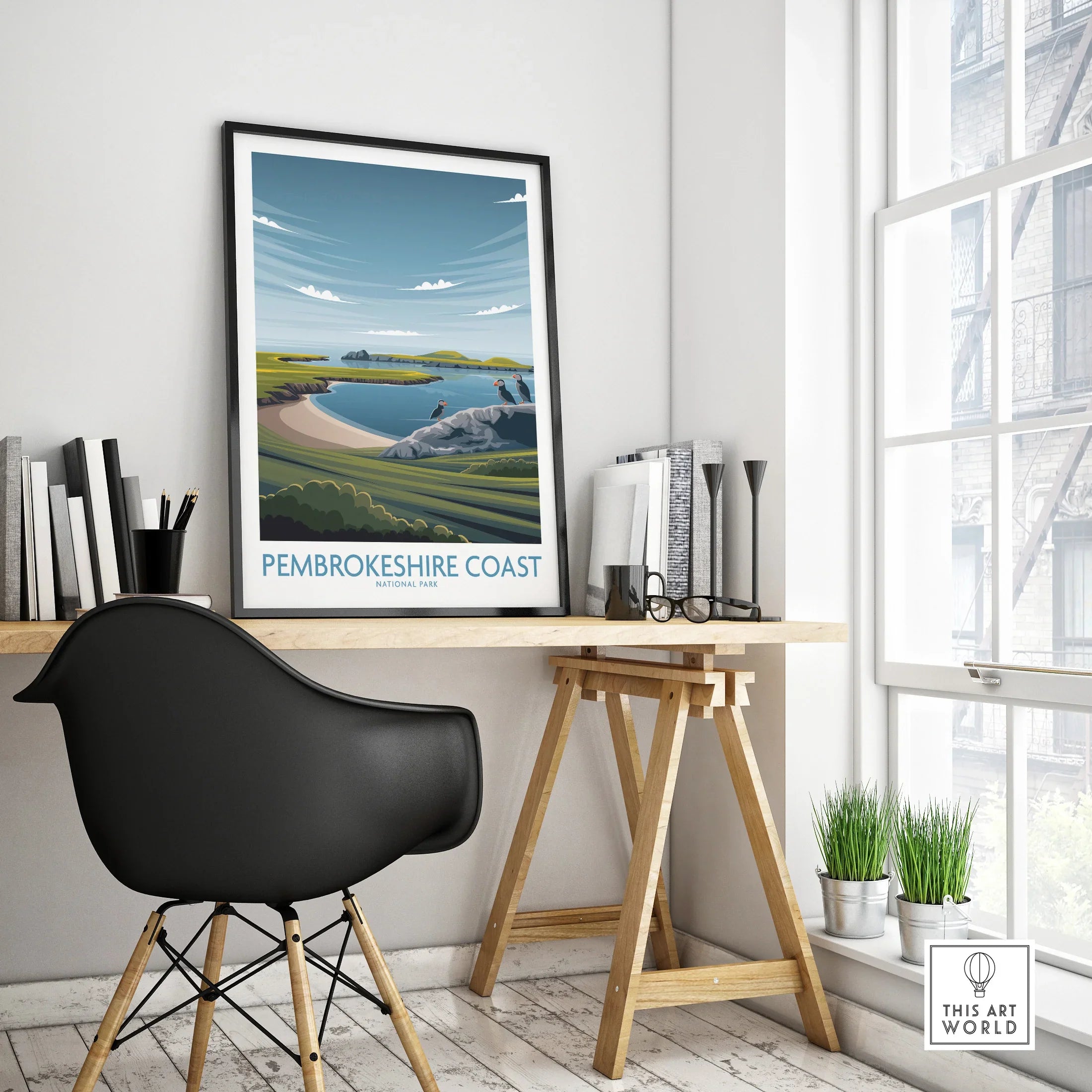 Framed Pembrokeshire Coast travel poster on modern office desk by window
