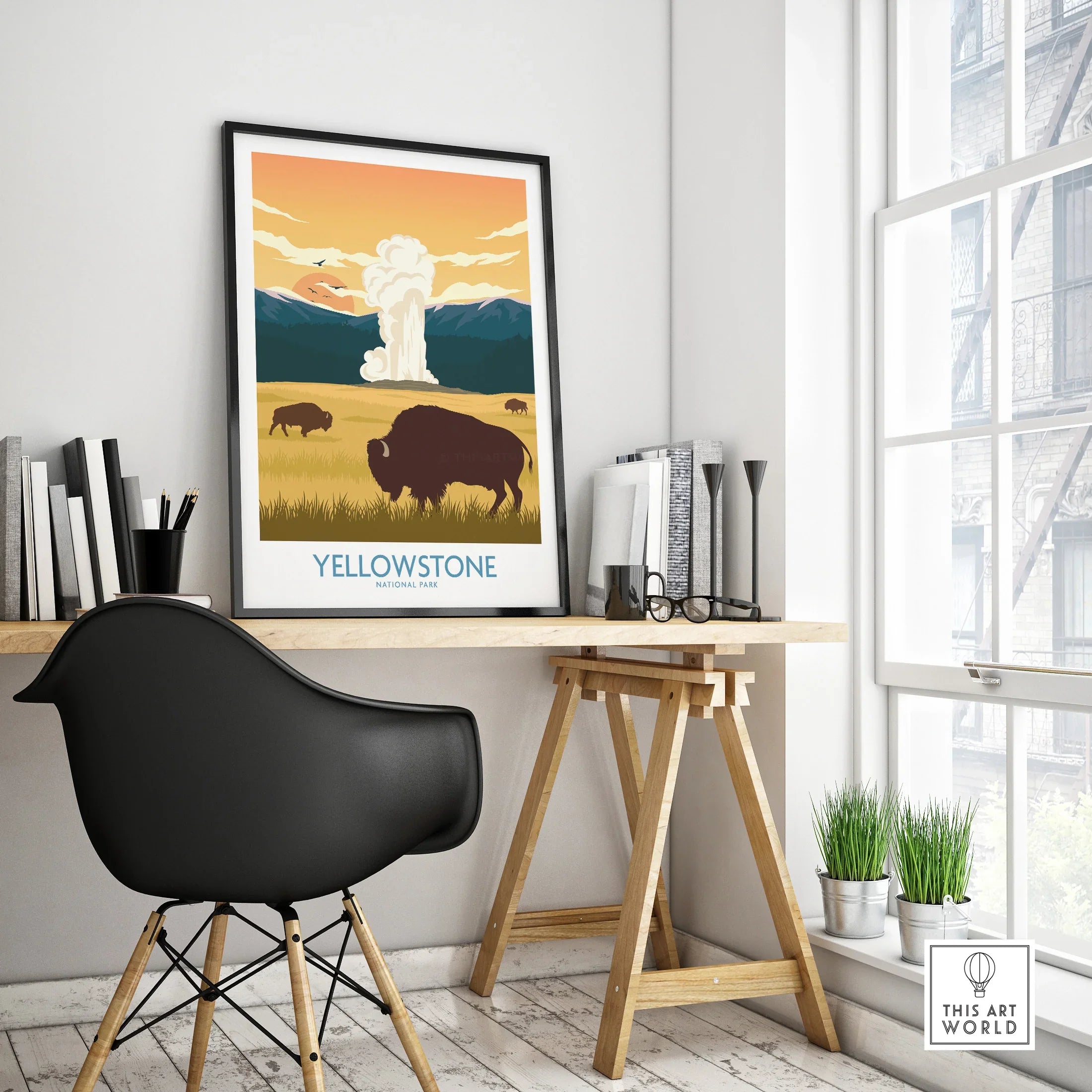 Yellowstone National Park poster with bison and geyser in black frame on modern desk