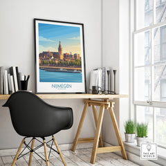 Framed Nijmegen cityscape travel poster on modern office desk near window