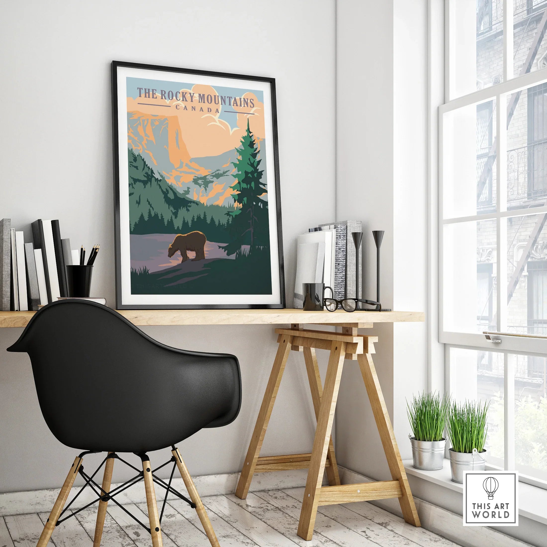 Rocky Mountains Canada travel poster in black frame on modern office desk, minimalist decor