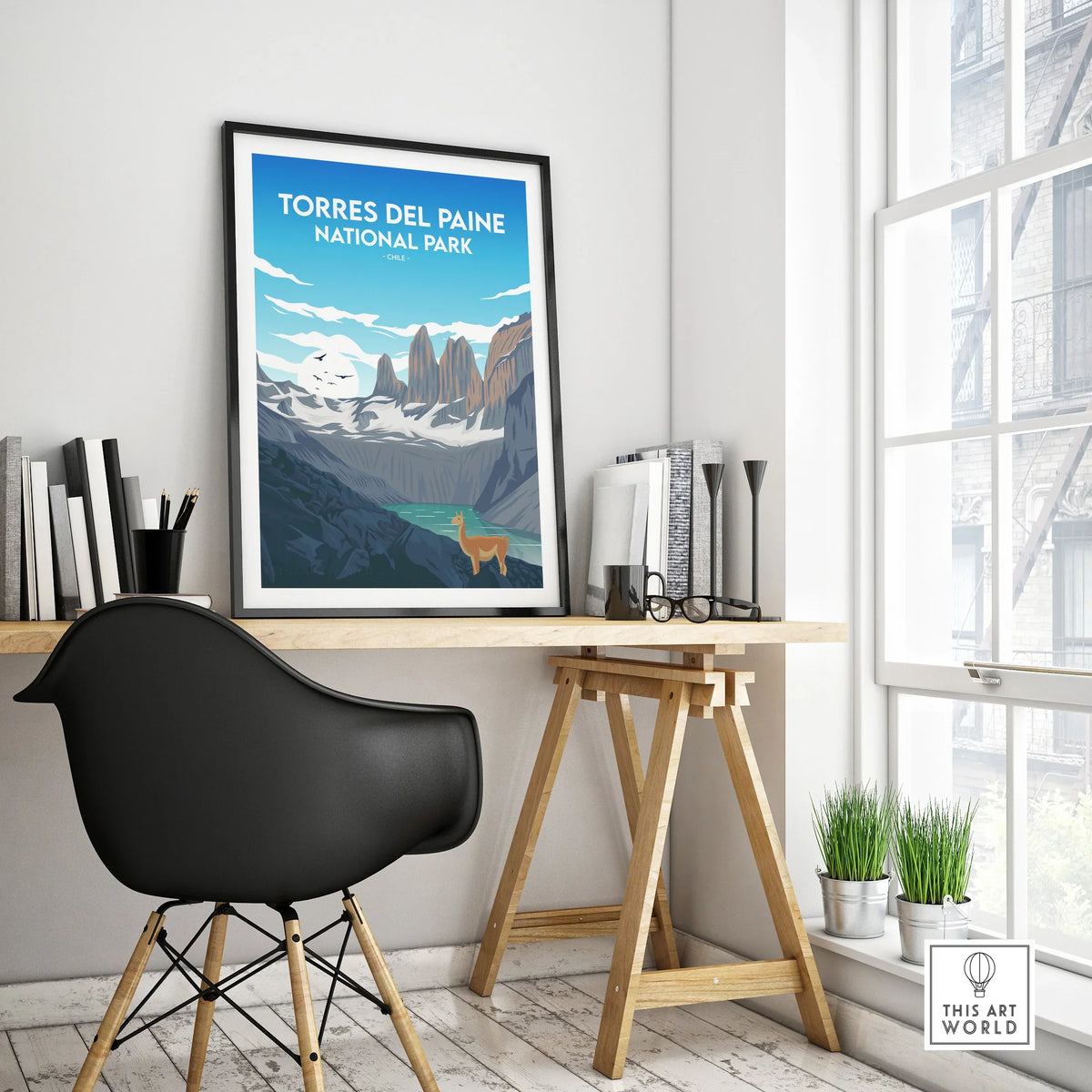 Framed Torres del Paine National Park travel poster on a modern home office desk