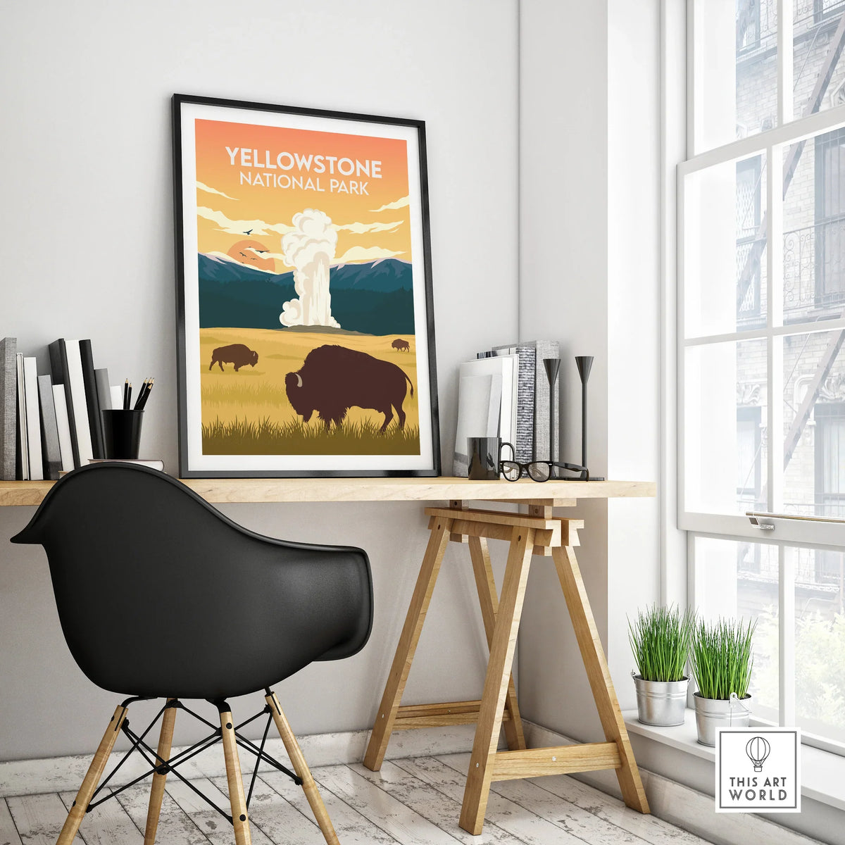 Yellowstone National Park poster with bison and geyser, framed on modern office desk
