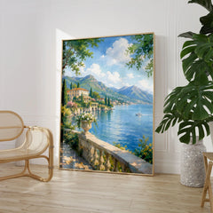 Lake Como lakeside villa and mountains watercolour art print large framed print beside a chair and plant