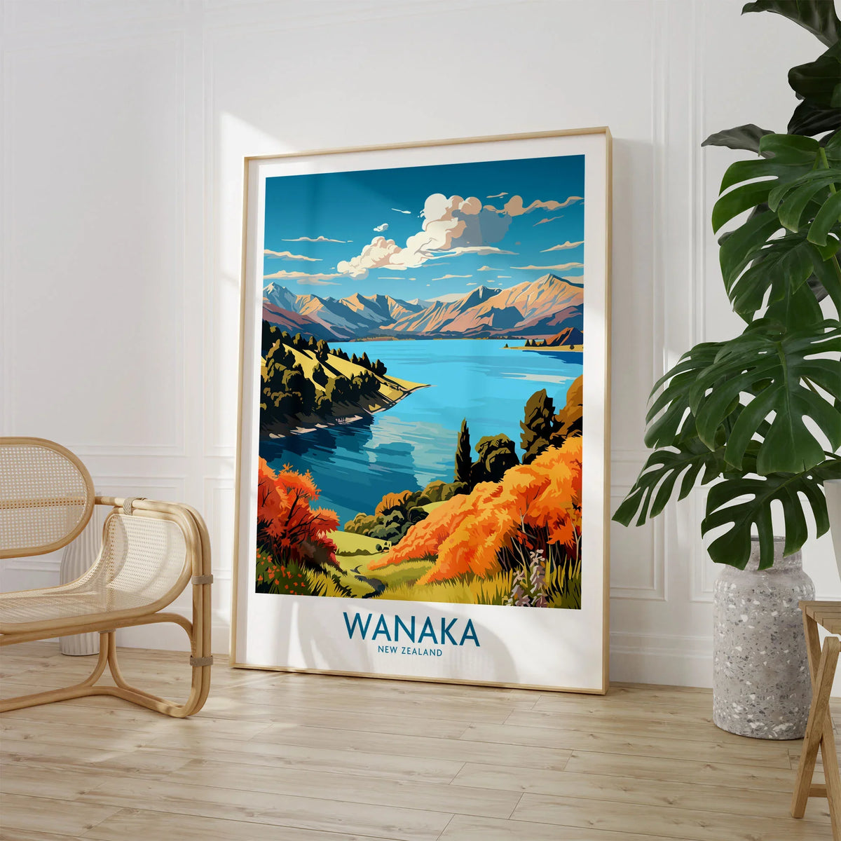 Wanaka Travel Poster New Zealand - large framed art print beside chair and plant