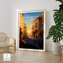 Aix-en-Provence Poster in a large natural wood frame leaning in a room with a rattan chair and monstera plant