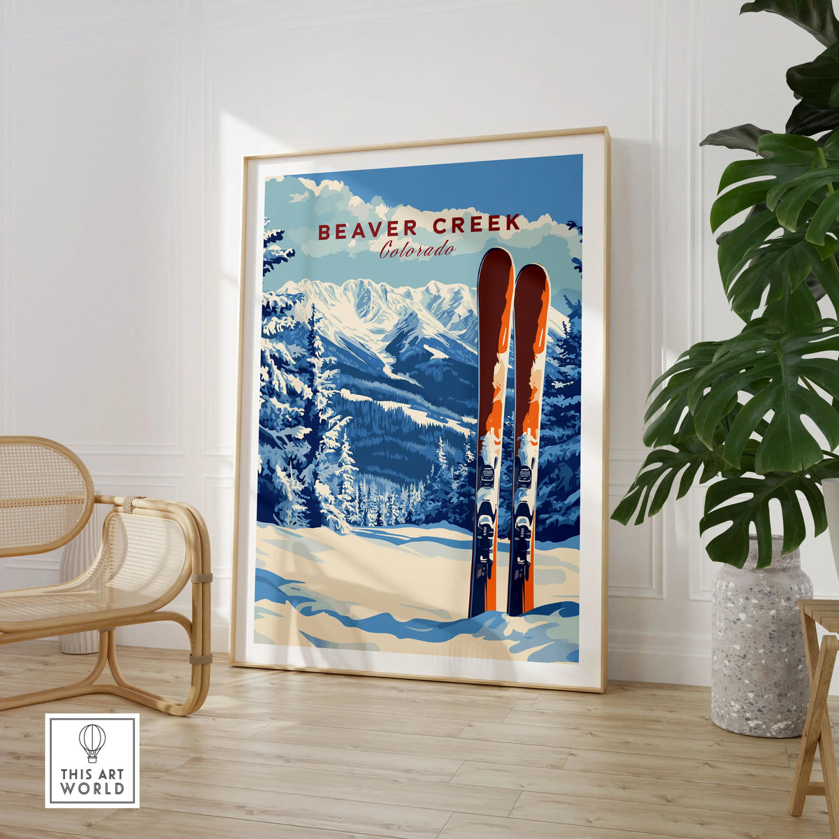 Beaver Creek Colorado Ski Poster - Rocky Mountain Winter Art Print in a large natural wood frame leaning in a room with a rattan chair and monstera plant