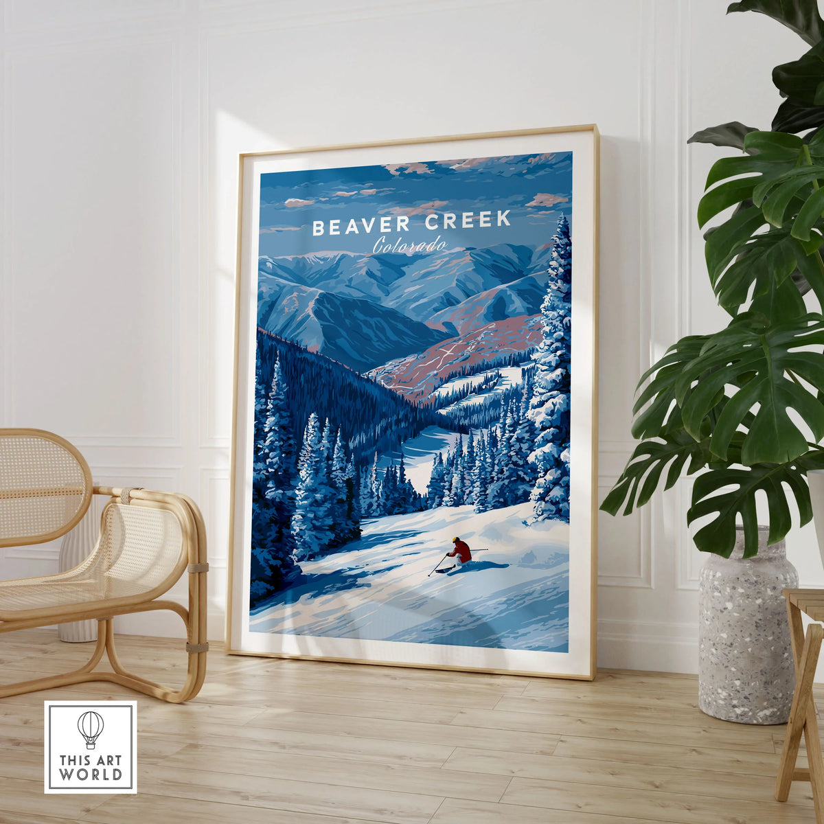 Beaver Creek Colorado Solo Skier Wall Art - Mountain Adventure Print in a large natural wood frame leaning in a room with a rattan chair and monstera plant