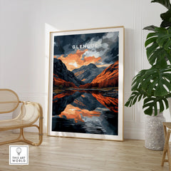 Glencoe Wall Art in a large natural wood frame leaning in a room with a rattan chair and monstera plant
