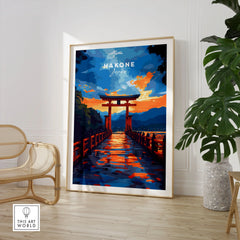 Hakone Wall Art Japan Torii Gate Sunset Reflections Poster - Vibrant Lake Ashi Print in a large natural wood frame leaning in a room with a rattan chair and monstera plant