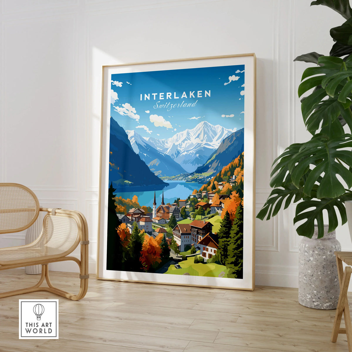 Interlaken Poster in a large natural wood frame leaning in a room with a rattan chair and monstera plant