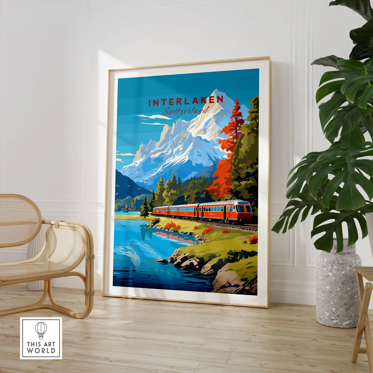 Interlaken Print Switzerland in a large natural wood frame leaning in a room with a rattan chair and monstera plant